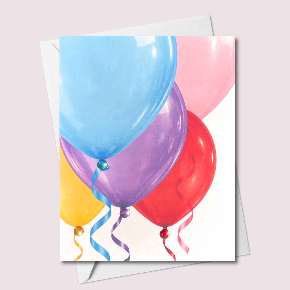 Russell Jeffrey Design greeting card featuring colourful balloons, curling ribbons and matching jewel accents, shown with a white envelope.