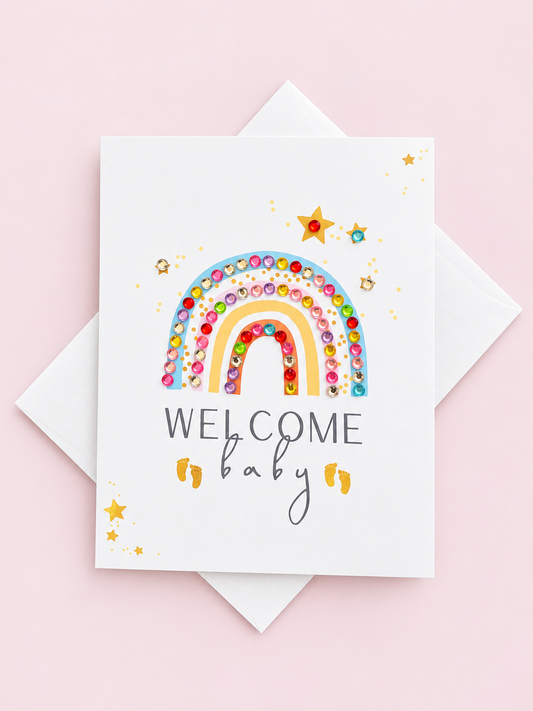 Welcome Baby Rainbow Pastel greeting card with its original design, shown with a white envelope on a pale pink background