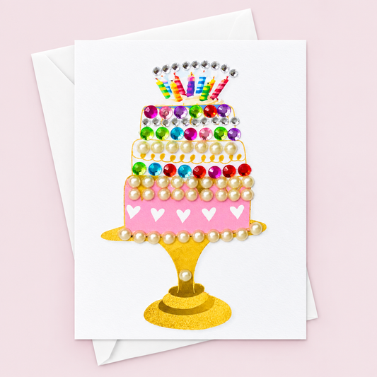 Birthday Cake with white envelope on a pale pink background