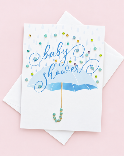 Blue Baby Shower Umbrella Greeting Card greeting card with its original design, shown with a white envelope on a pale pink background