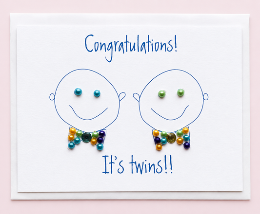 Congratulations Its Twin Boys greeting card with hand-applied sparkling details with a white envelope on pale pink