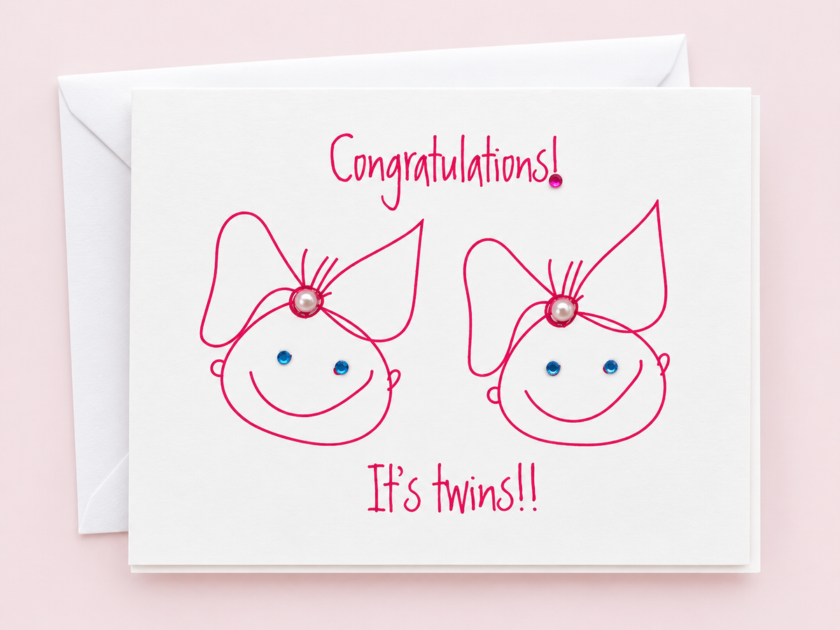 Congratulations Its Twin Girls greeting card with hand-applied sparkling details with a white envelope on pale pink