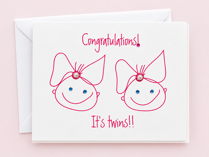 Congratulations Its Twin Girls greeting card with hand-applied sparkling details with a white envelope on pale pink