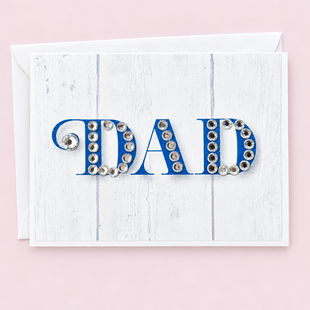 DAD Blue Sparkle Greeting Card with white envelope on a pale pink background