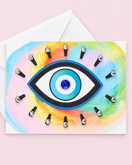 Evil Eye Protection Multi-Colour greeting card with its original design, shown with a white envelope on a pale pink background