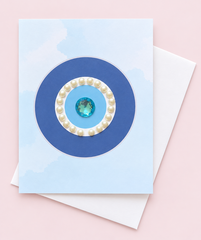 Evil Eye Protection with Pearls minimalist greeting card with its original design, shown with a white envelope on a pale pink background