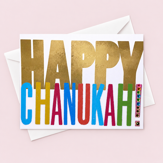 Happy Chanukah greeting card with hand-applied sparkling jewel details with a white envelope on pale pink