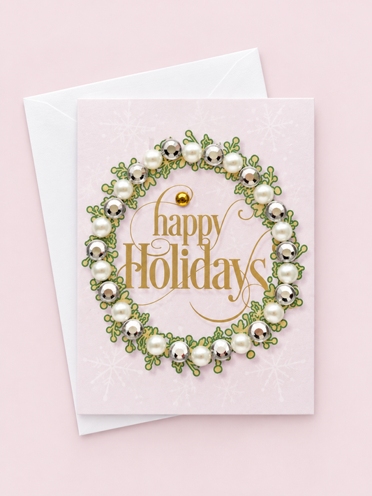 Happy holidays mini with a white envelope on a pale pink background