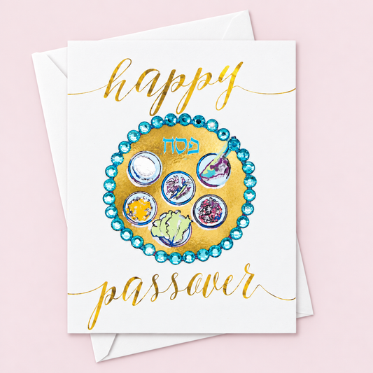 Happy Passover Gold and Blue Sedar Plate Greeting Card with white envelope on a pale pink background