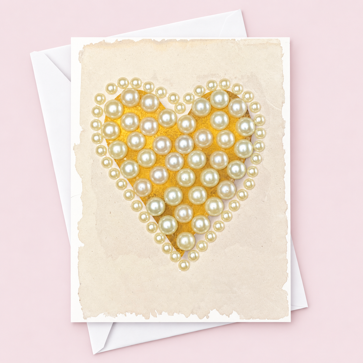 Pearl Heart with a white envelope on a pale pink background