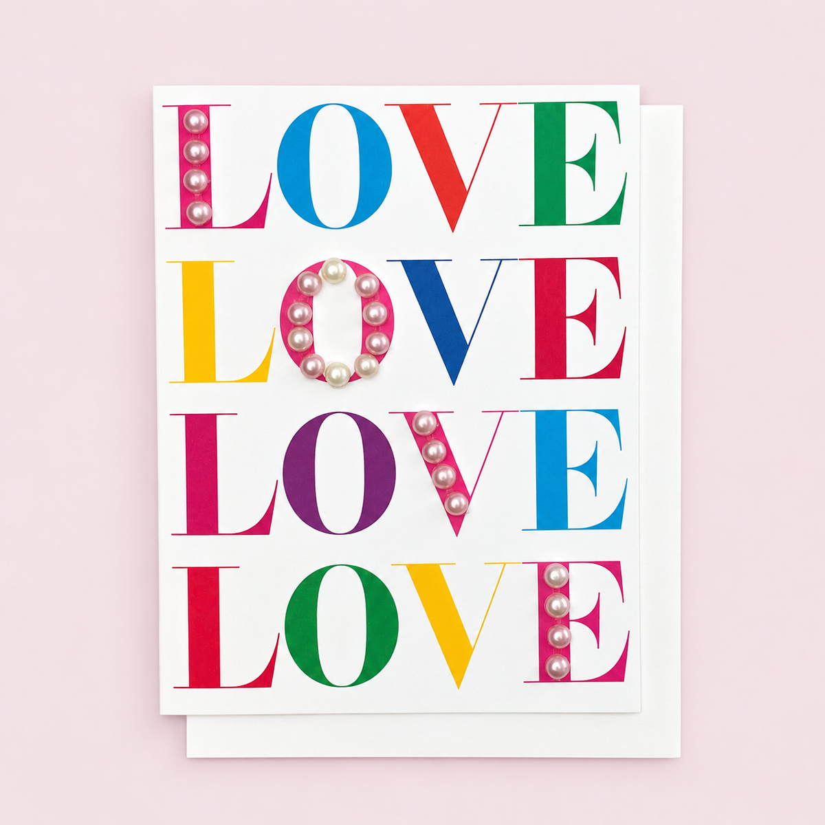 Multicoloured Love Love Love Love with a white envelope on a pale pink background