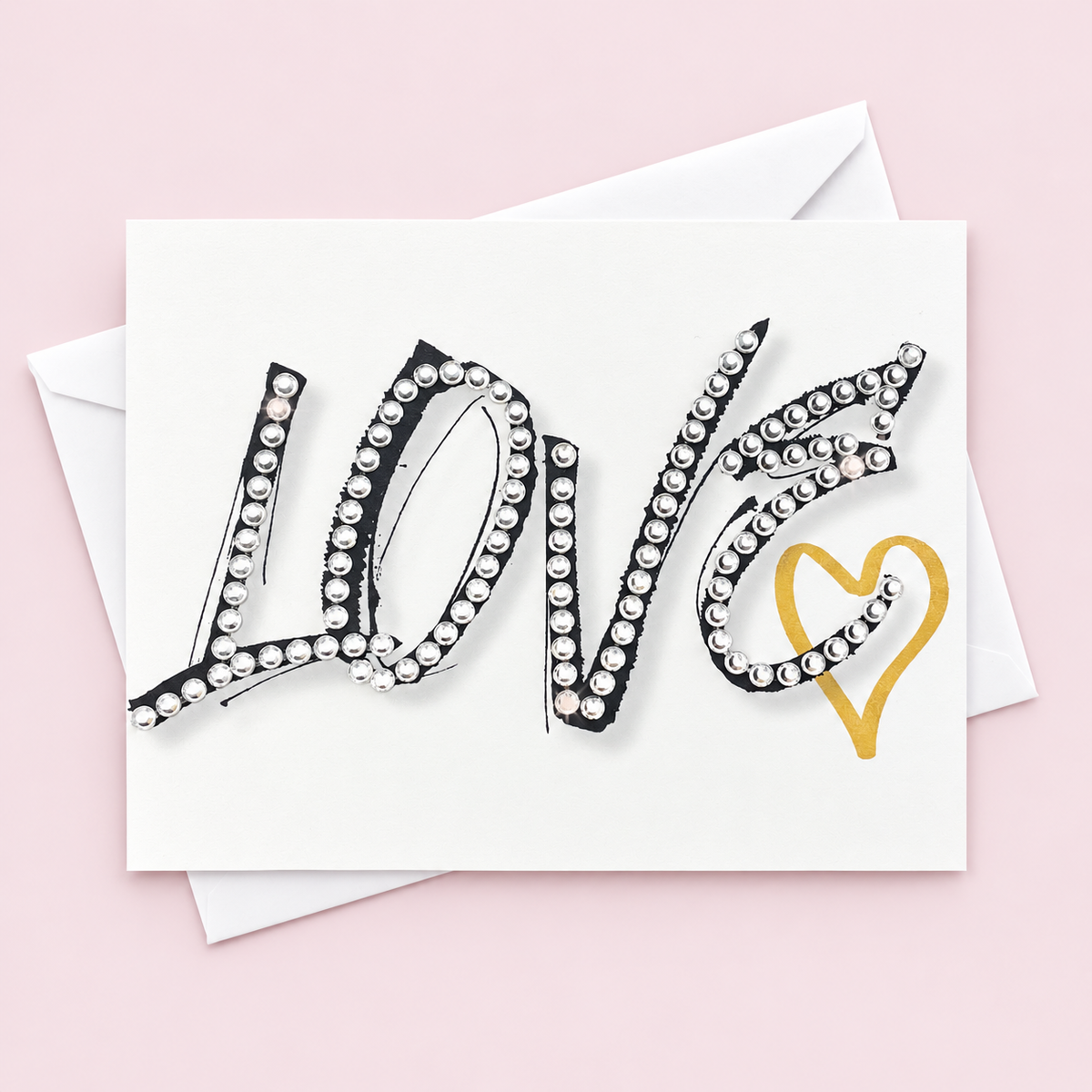 Crystal Love greeting card with gold heart and hand-applied crystal details with a white envelope on pale pink