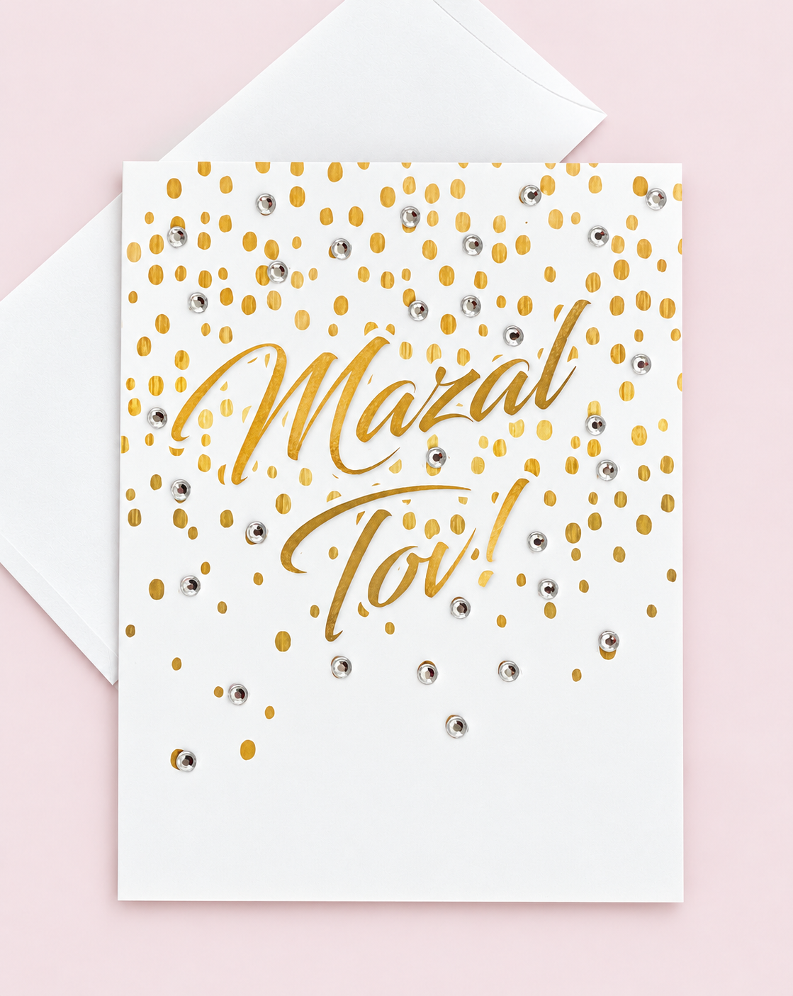 Mazal Tov with Gold Confetti greeting card with its original design, shown with a white envelope on a pale pink background