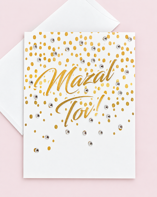 Mazal Tov with Gold Confetti greeting card with its original design, shown with a white envelope on a pale pink background