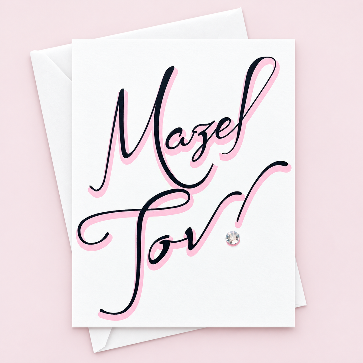 Mazel Tov Black and Pink Font greeting card with its original design, shown with a white envelope on a pale pink background