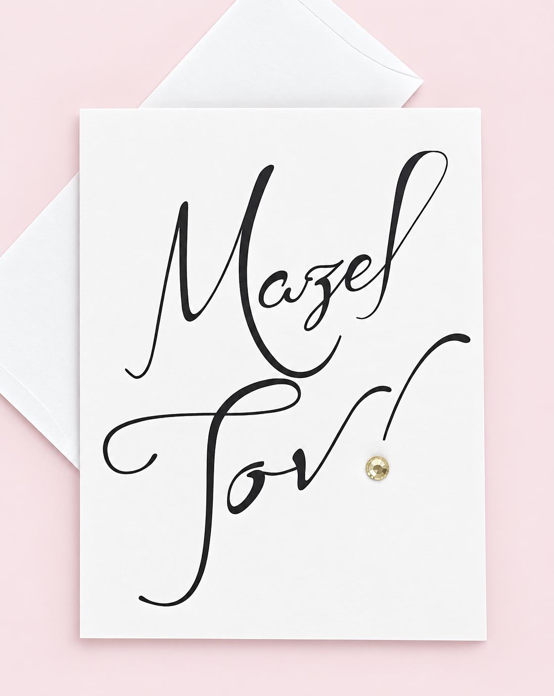 Mazel Tov Black Script greeting card with its original design, shown with a white envelope on a pale pink background