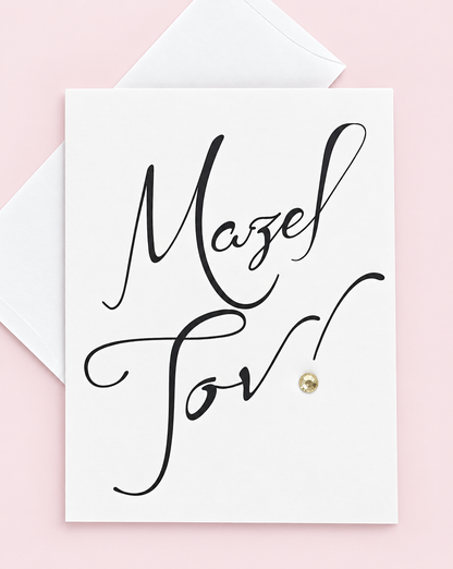 Mazel Tov Black Script greeting card with its original design, shown with a white envelope on a pale pink background