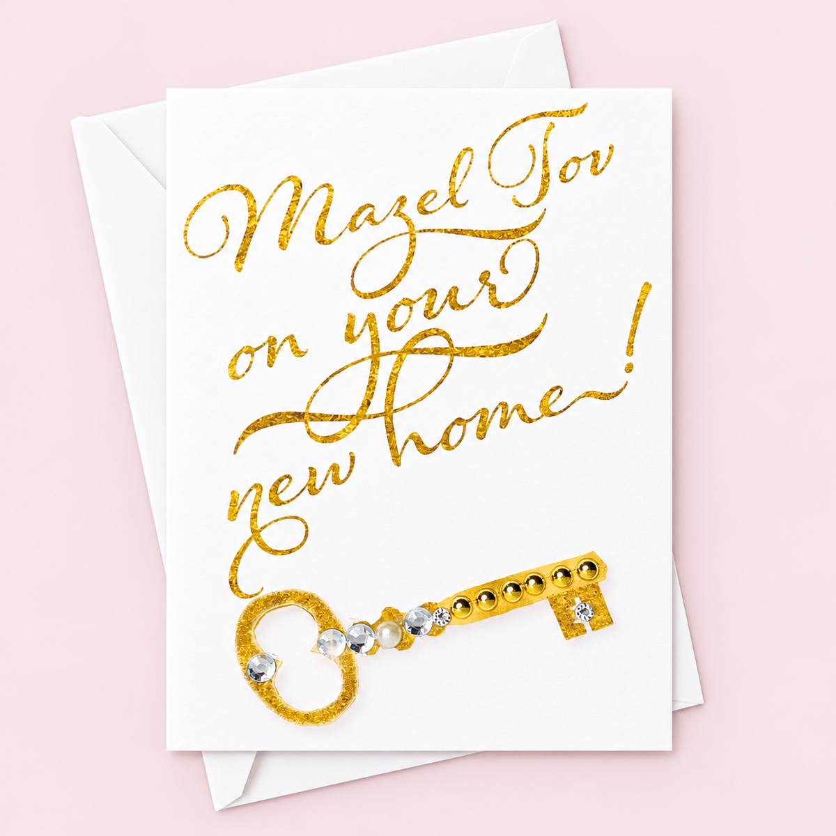 Mazel Tov on your New Home greeting card with its original design, shown with a white envelope on a pale pink background