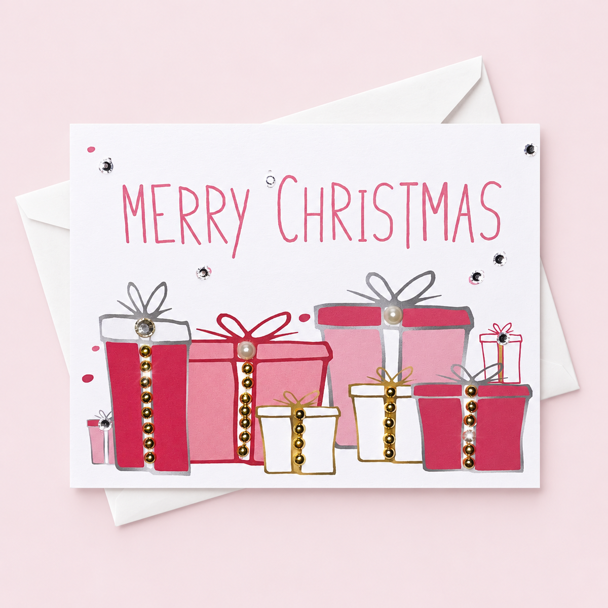 Merry Christmas Pink Presents Greeting Card with a white envelope on a pale pink background