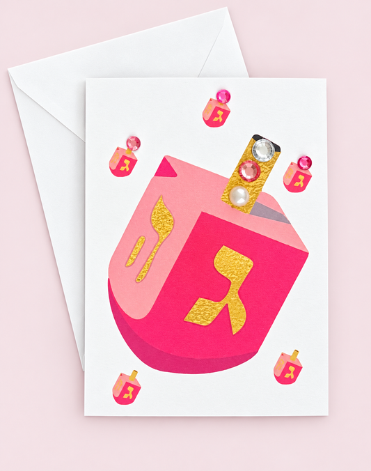 Mini Chanukah Driedel in Pink greeting card with its original design, shown with a white envelope on a pale pink background