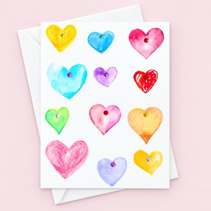 Multi-Hearts Watercolour with a white envelope on a pale pink background