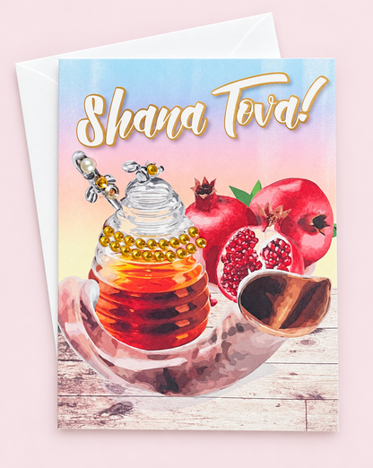 Shana Tova! Pomegranate & Honey Jar greeting card with its original design, shown with a white envelope on a pale pink background