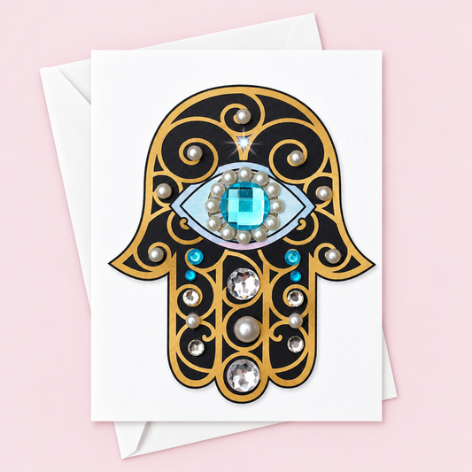 Black & Gold Hamsa Greeting Card – Hand-Embellished Crystals with a white envelope on a pale pink background