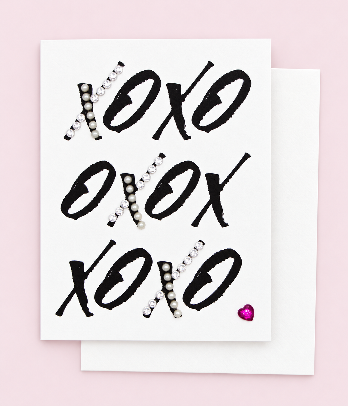 XOXOXOXO Heart Greeting Card with white envelope on a pale pink background