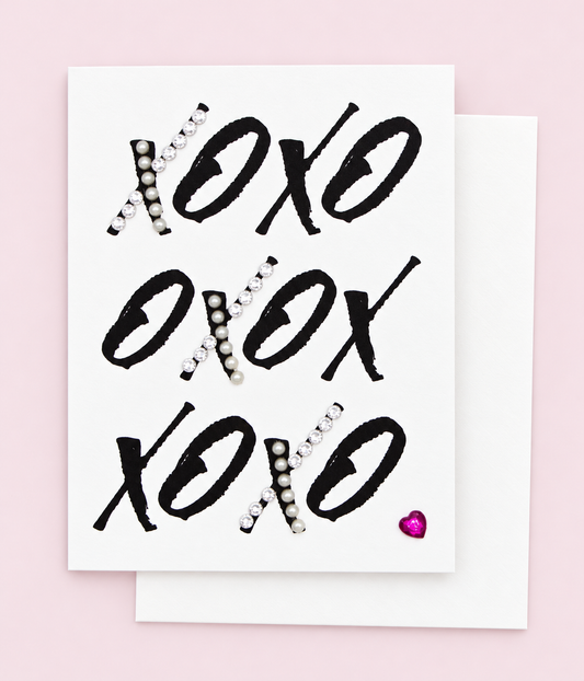 XOXOXOXO Heart Greeting Card with white envelope on a pale pink background
